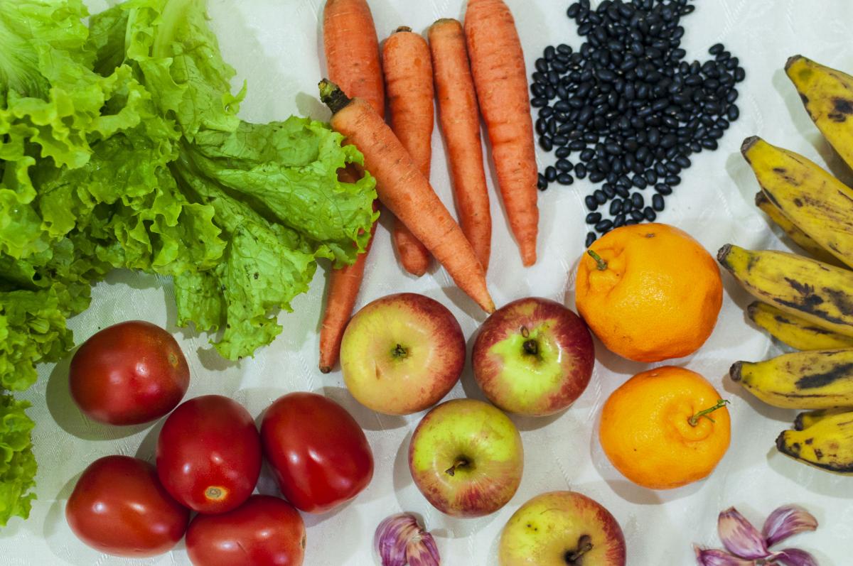 Fotografia de alimentos: alface, tomate, cenoura, maçã, banana, alho e feijão