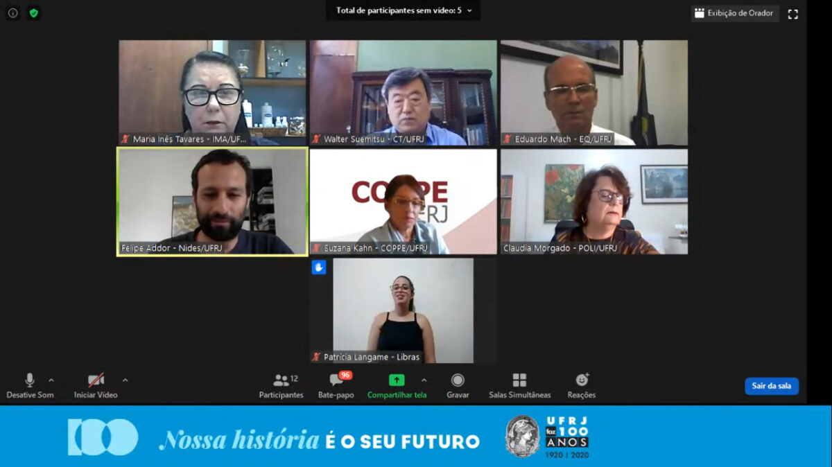 Captura de tela do debate sobre tecnologia. A tela é dividida em sete partes, exibindo os seis participantes e a intérprete de Libras.