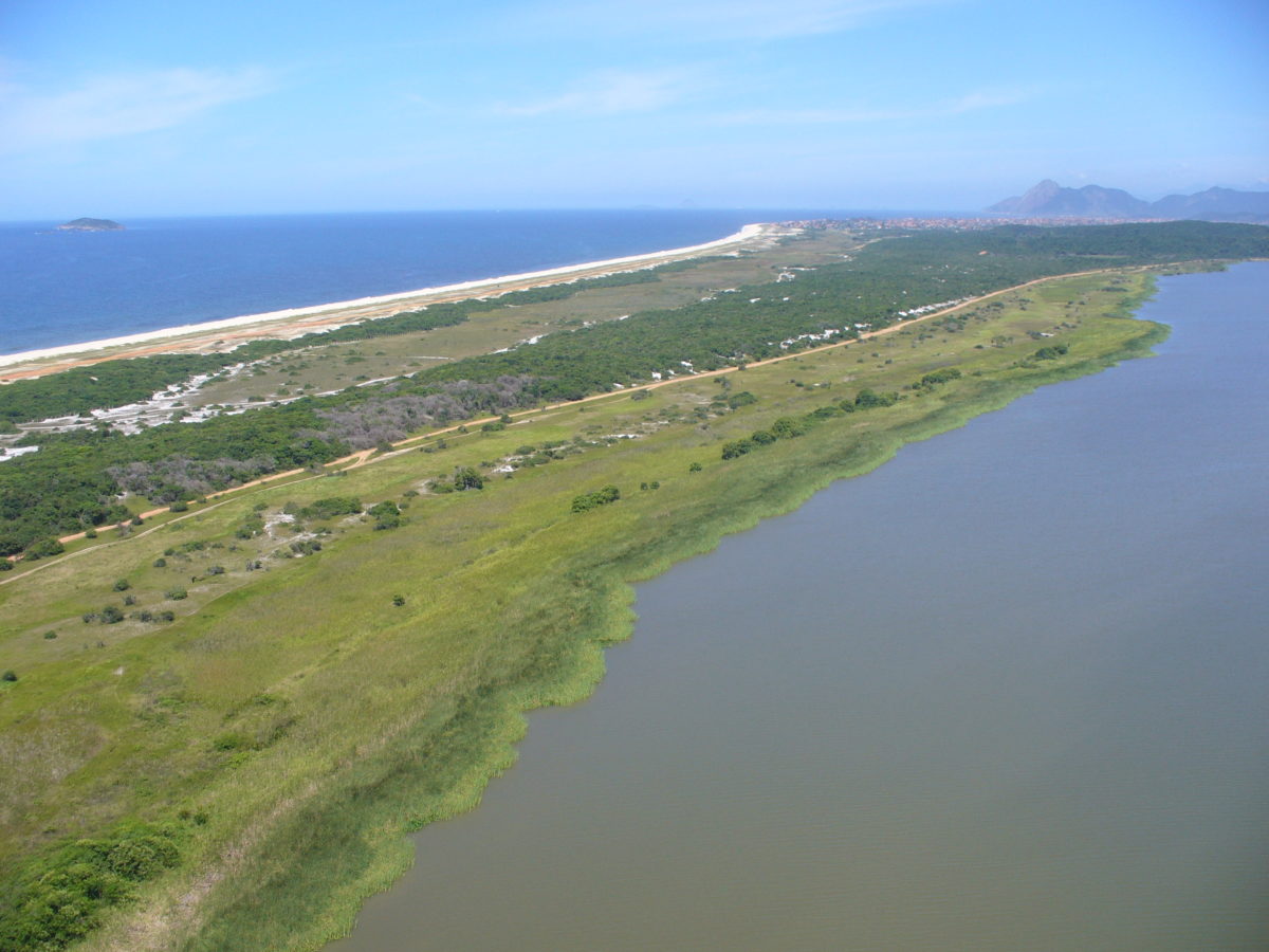 Vista da Área de Proteção Ambiental de Maricá. De um lado, a faixa de areia e o oceano, de outro a lagoa e a restinga.