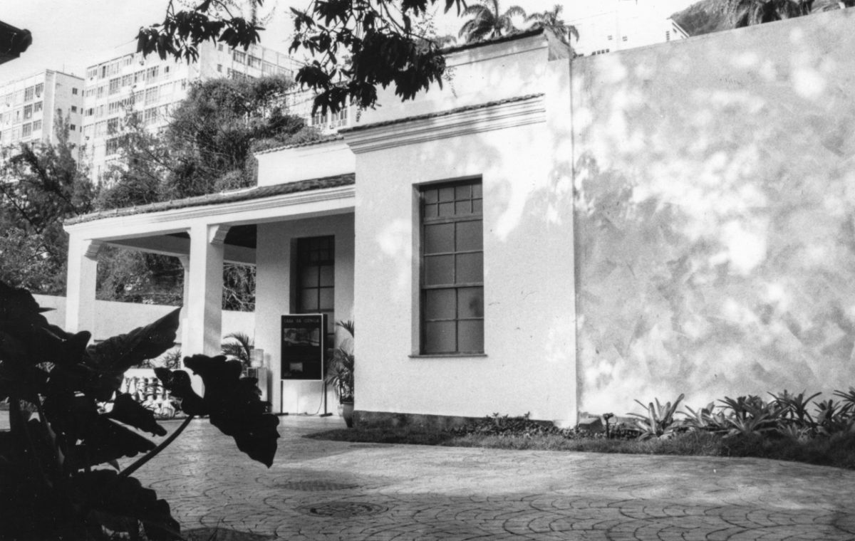 Fotografia em preto branco mostra a fachada da Casa da Ciência, construção térrea com varanda e duas janelas na face exposta para a foto.