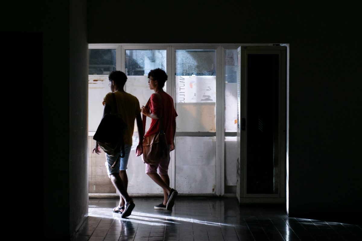 Dois alunos saem por uma porta