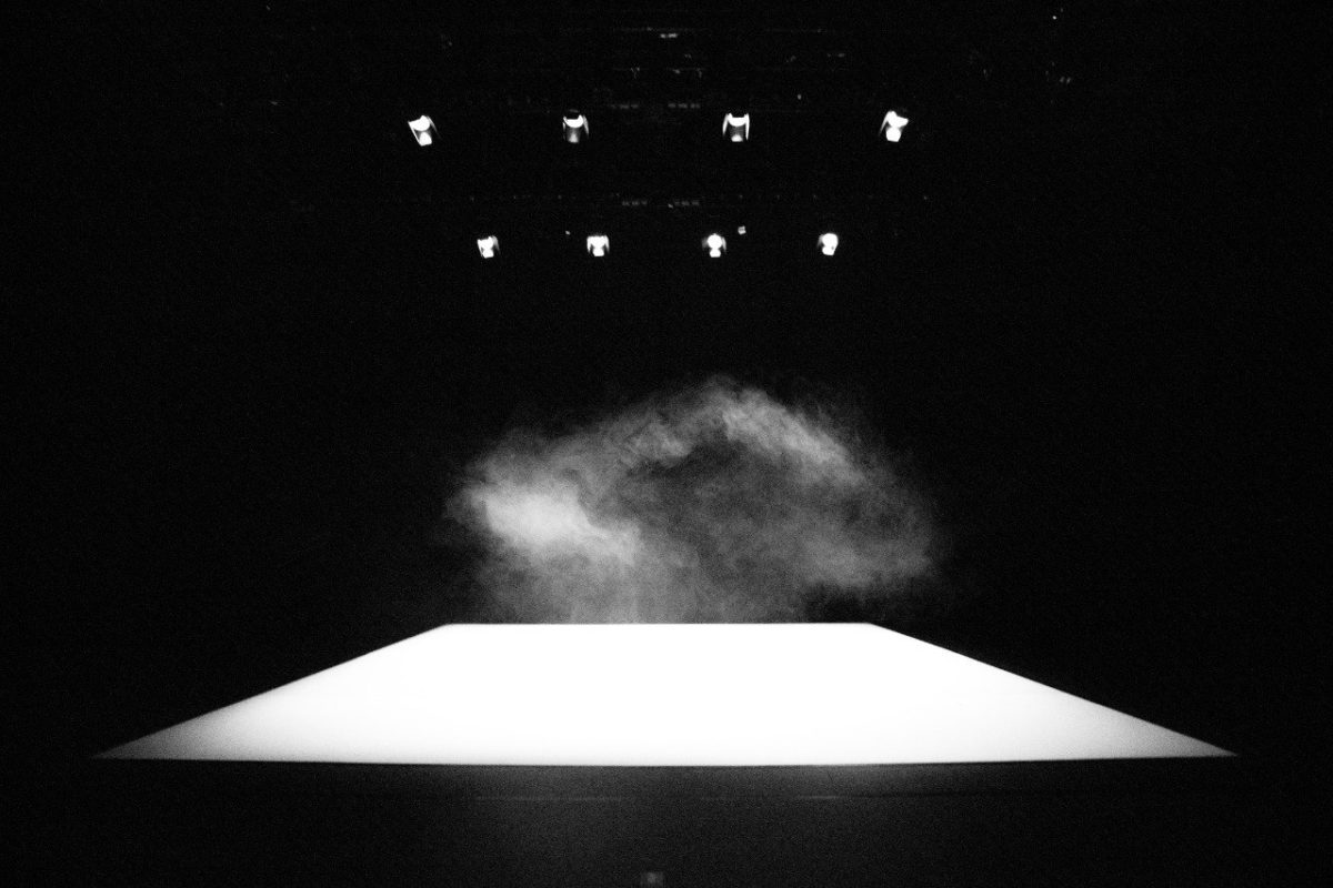 foto em preto e branco mostra palco vazio, com poeira aparecendo