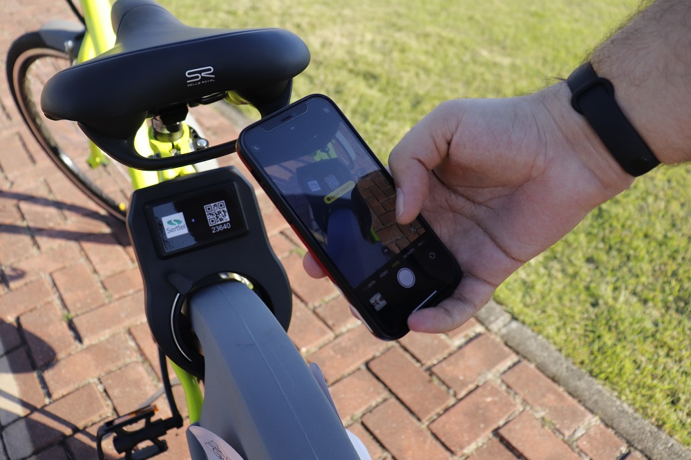 Um celular tira foto de um QR Code em uma das bicicletas