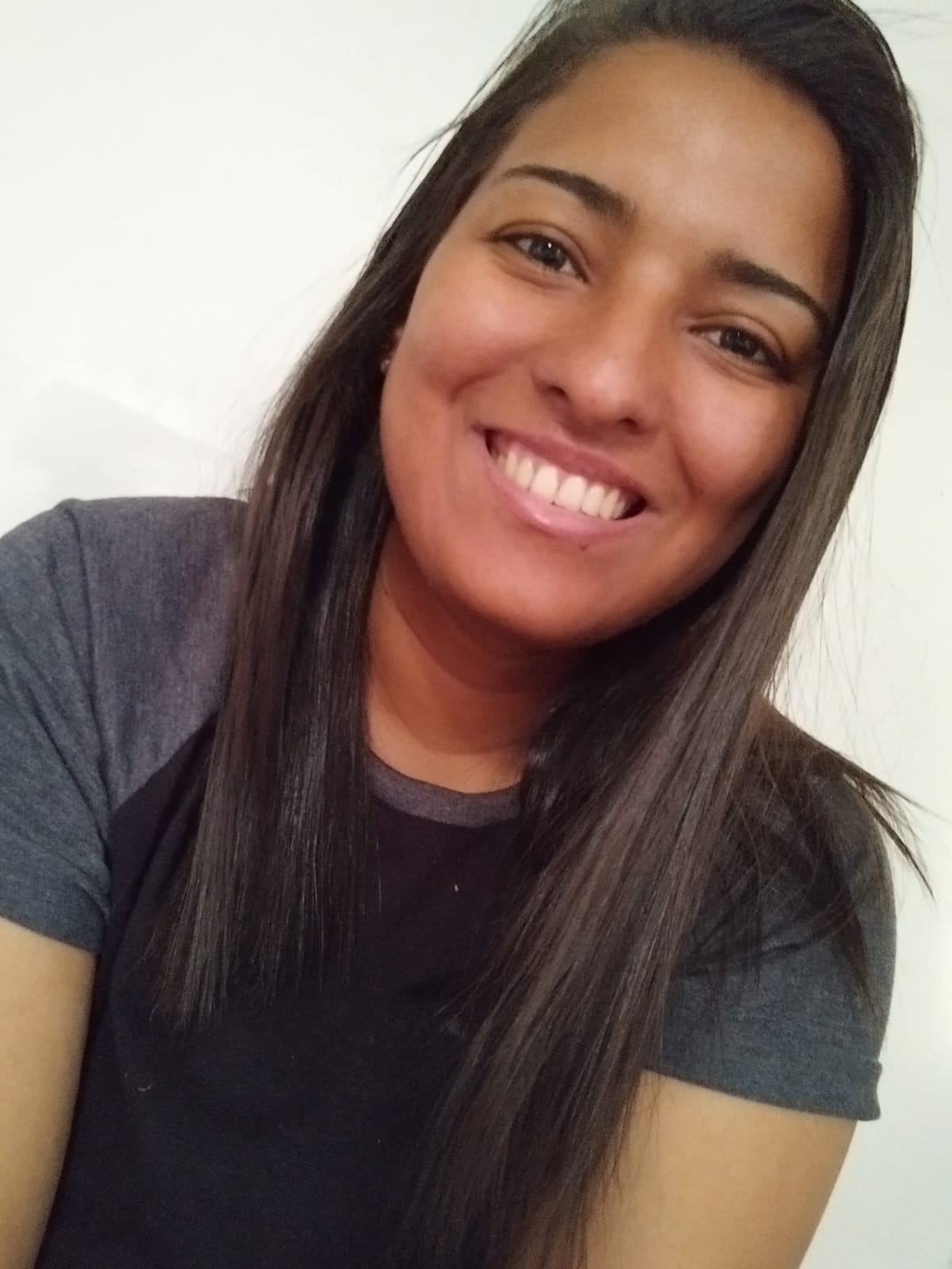 Mulher negra com cabelo liso sorri para a câmera