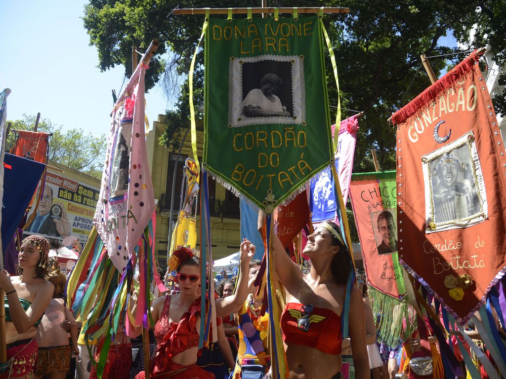 Foliões seguram estandartes do Cordão do Boitatá pelas ruas do Centro do Rio