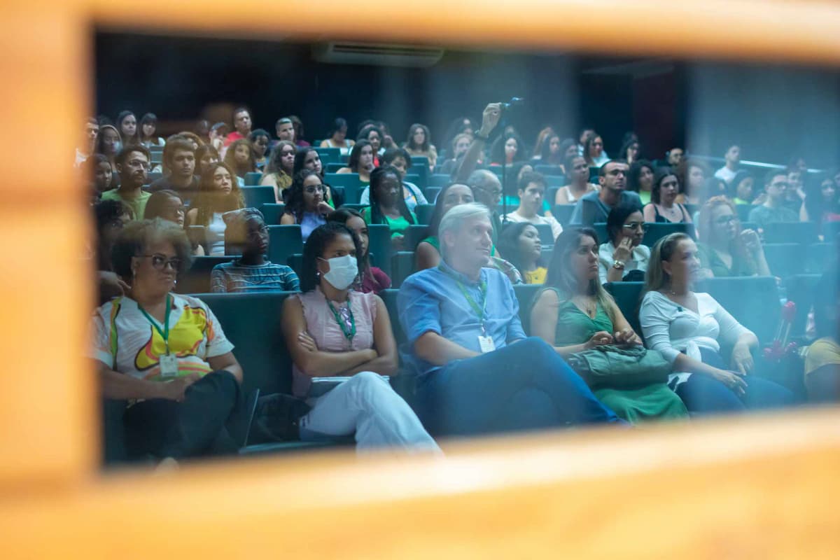 Fotografia de uma plateia em um auditório lotado.