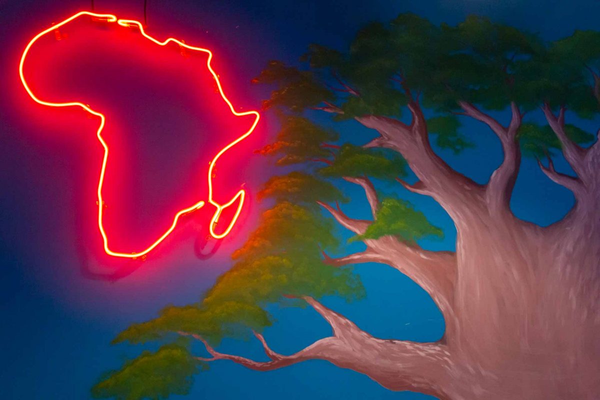 Mapa da África em letreiro vermelho ao lado da imagem de uma árvore baobá 
