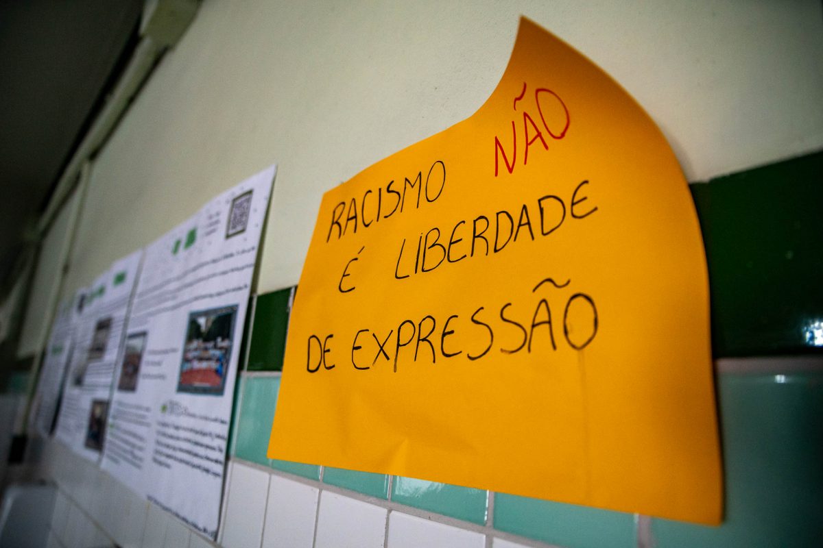 Fotografia de um cartaz amarelo, em que está escrita a frase: Racismo não é liberdade de expressão.