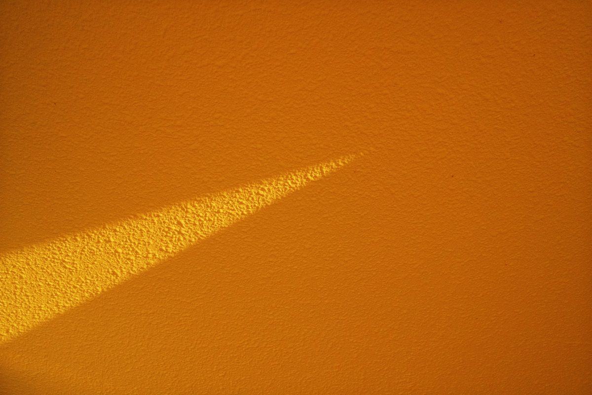 Um feixe de sol toca uma parede amarela
