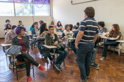 Foto de estudantes em sala de aula recebendo instruções para o teste de habilidade específica, oferecido nas áreas de dança, música, pintura e arquitetura.