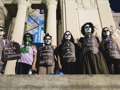 Foto colorida de performance que denuncia a morte de mulheres durante a manifestação pela descriminalização do aborto, no Centro da Cidade, no dia oito de agosto.